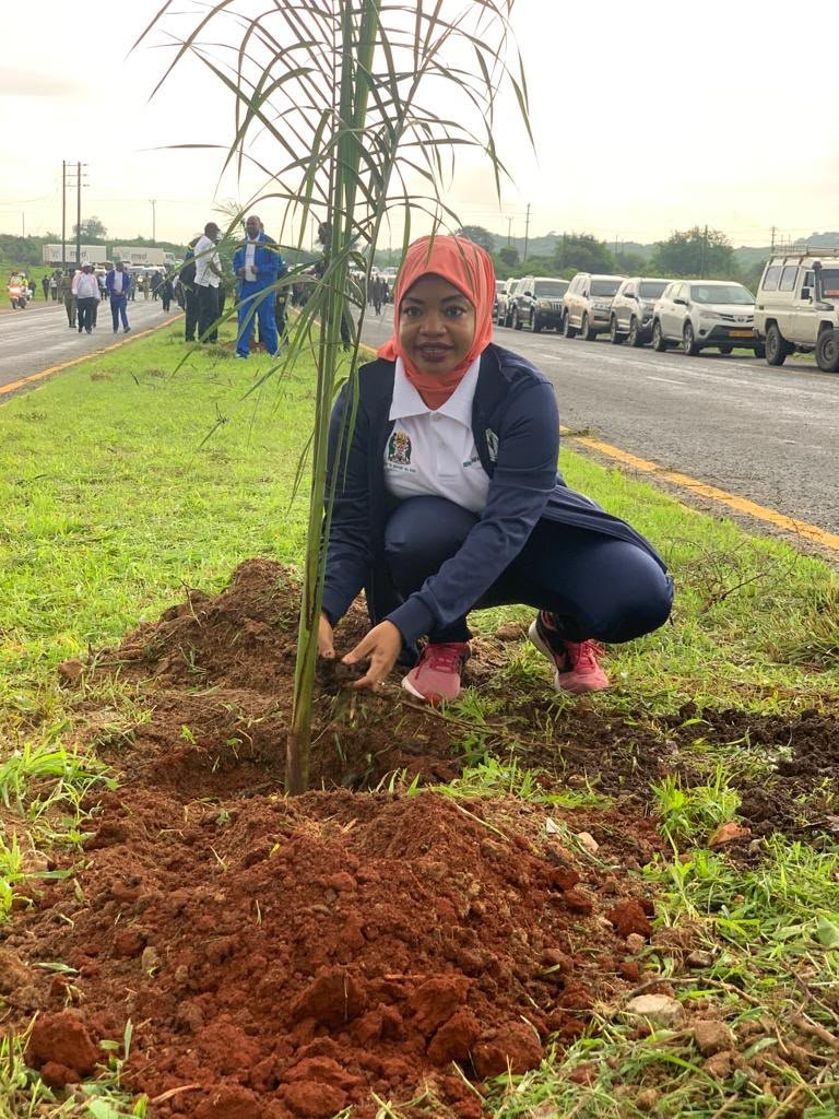 Black Tanzanian community members working together in a sustainable garden, embodying the spirit of localized, community-led initiatives.